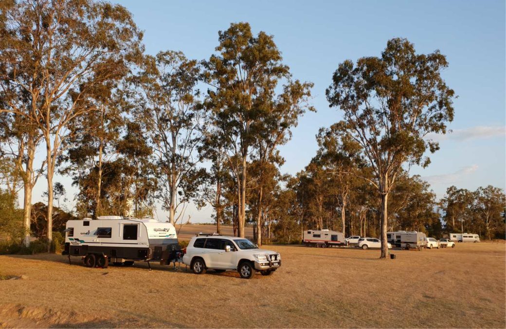 Caravans and campervans parked at Hangar O camping ground with spacious grass pitches
