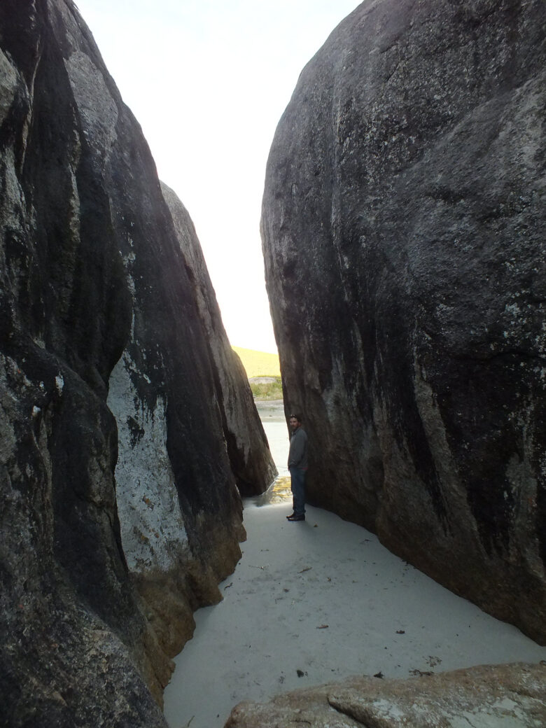 Hiker walking through rocky entrance path into Elephant Cove, WA