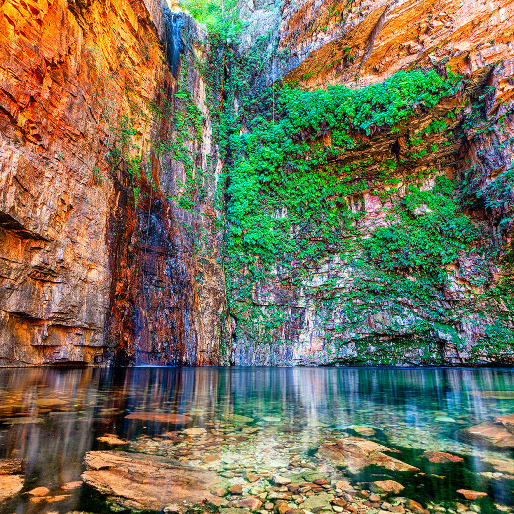 Crystal clear swimming hole surrounded by red rock cliffs at Emma Gorge, El Questro