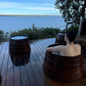 Outdoor hot tubs overlooking calm water at a scenic Australian destination