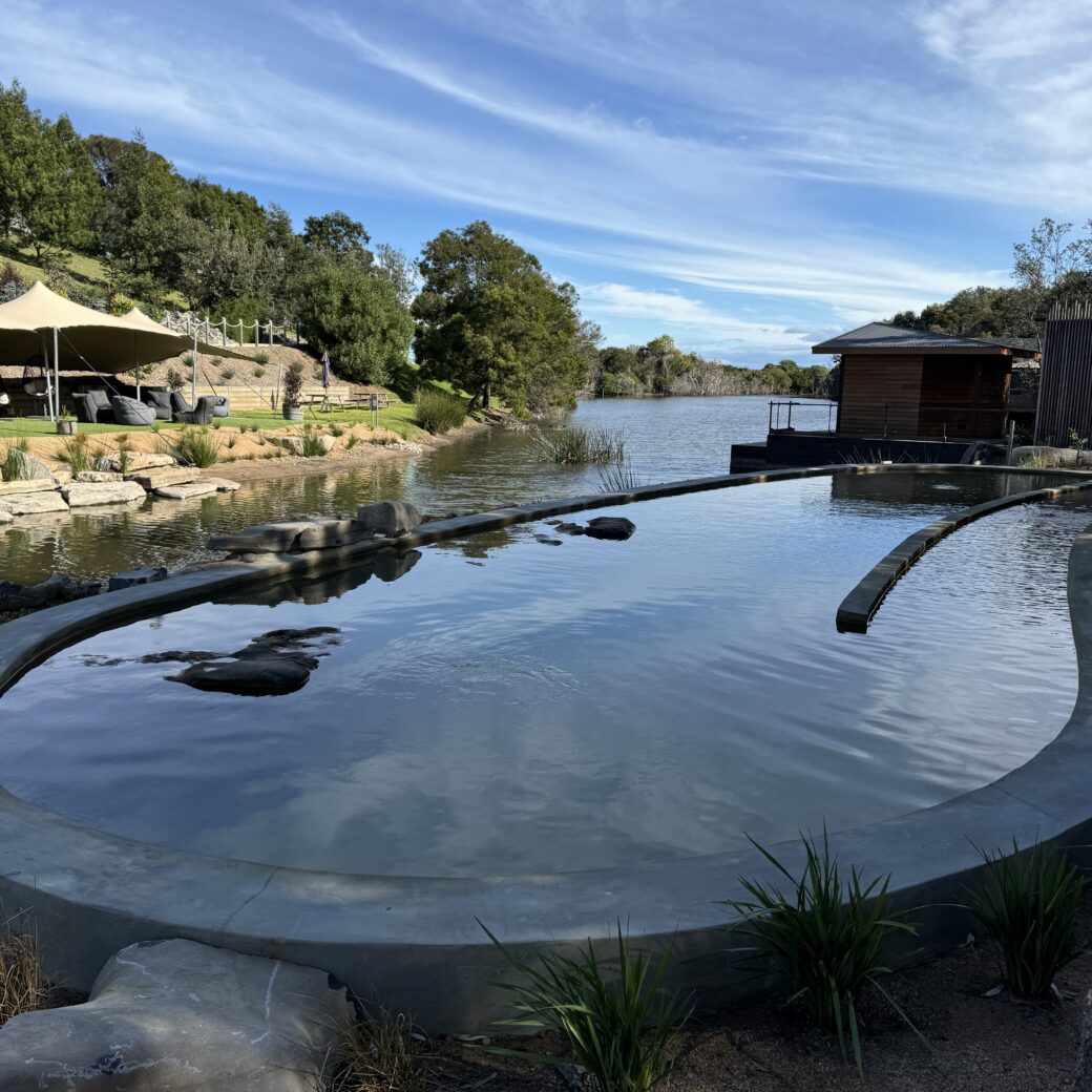 Lagoon-style swimming pool at Metung Hot Springs with surrounding bushland