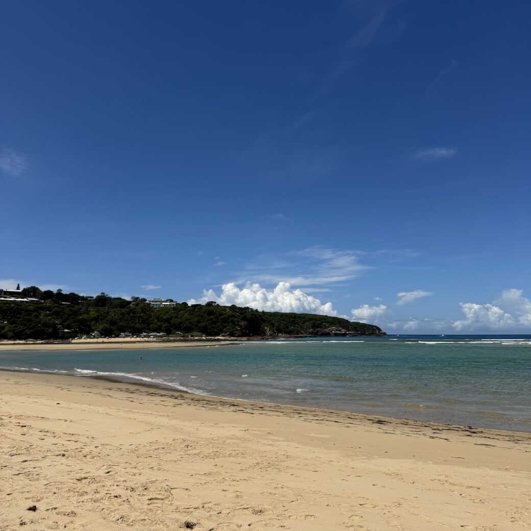 Merimbula Beach shoreline showing gentle waves ideal for family camping holidays