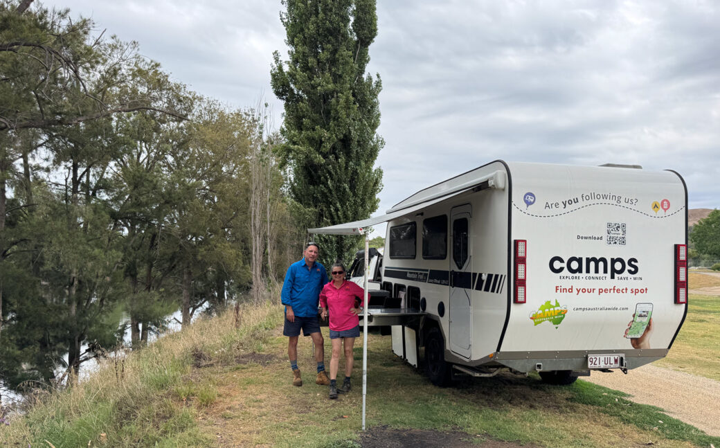 Couple camping at Jugiong Showgrounds with caravan and campfire setup