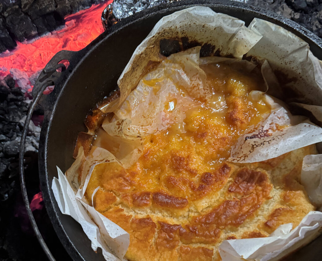 Warm self-saucing butterscotch pudding in a camping pot, perfect for family camping trips