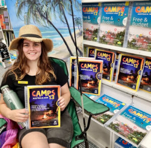 Woman holding CAMPS Australia Wide 13 guidebook at bookshop display